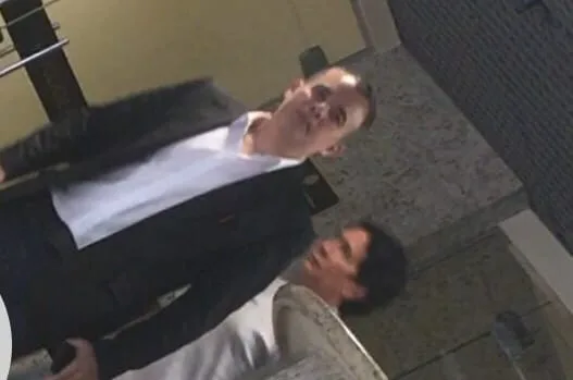 Waisser Botelho ladeado por dois advogados na saída da PF.